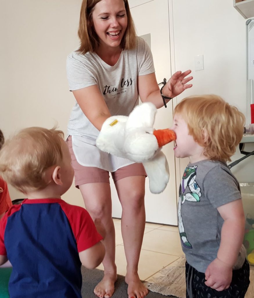Baby and toddlers playing with a puppet